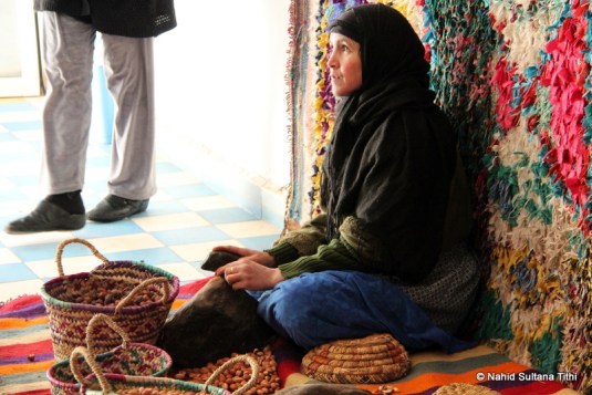 A lady breaking argan nuts in a road-side cosmetics store, on our way to Ouarzazate