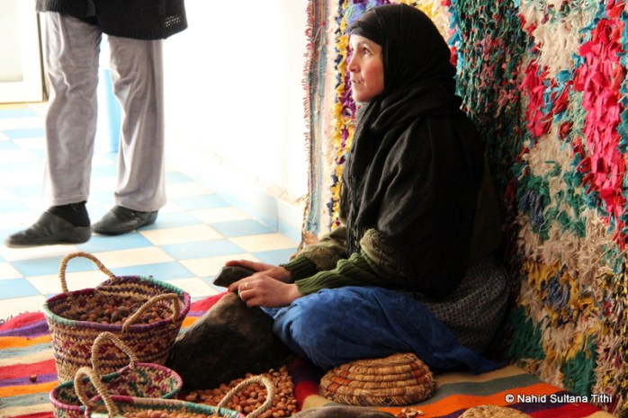 A lady breaking argan nuts in a road-side cosmetics store, on our way to Ouarzazate