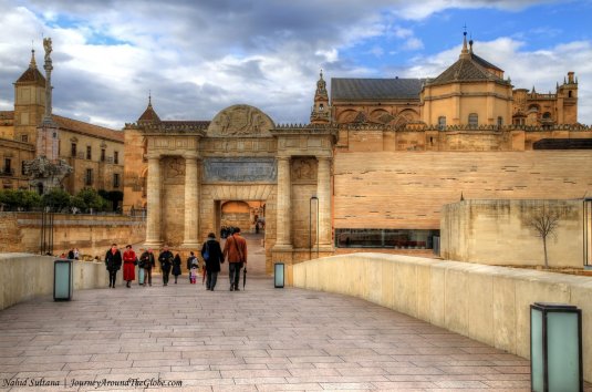 Walking on the Roman Bridge of Cordoba, Spain and looking at Mezquita