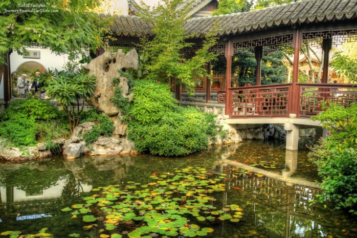 Trees, pond, and bridge in Lan Su Chinese Garden in Portland, Oregon