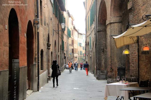 Walking thru an ancient alley in Old Siena, Italy